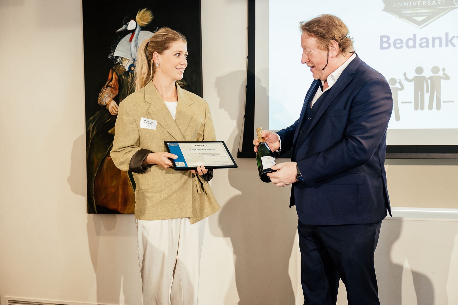 Een deelnemer ontvangt een certificaat van Dirk Van Goubergen bij Lean Academy